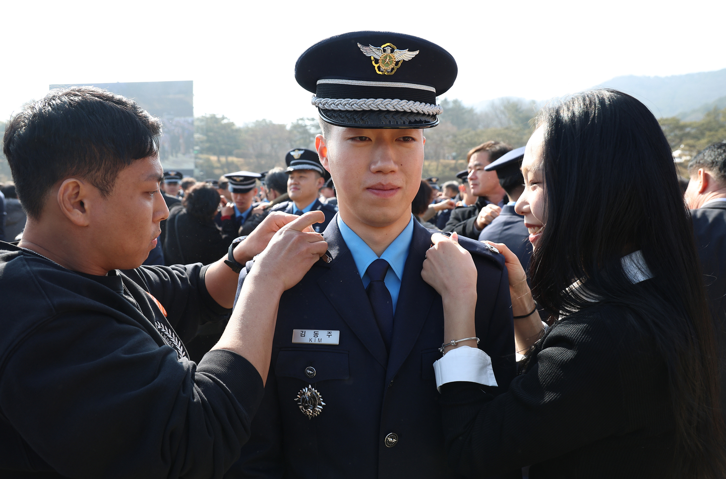 Family members of a newly commissioned officer pin on his insignia during a joint commissioning ceremony at the parade ground of Gyeryongdae in Gyeryong, South Chungcheong, on Feb. 20. [NEWS1] 