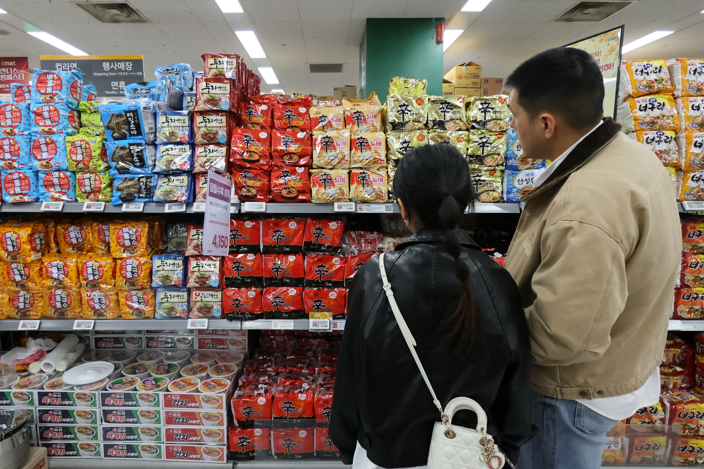 Shoppers look at instant noodles at a supermarket in Seoul on April 3. [YONHAP]