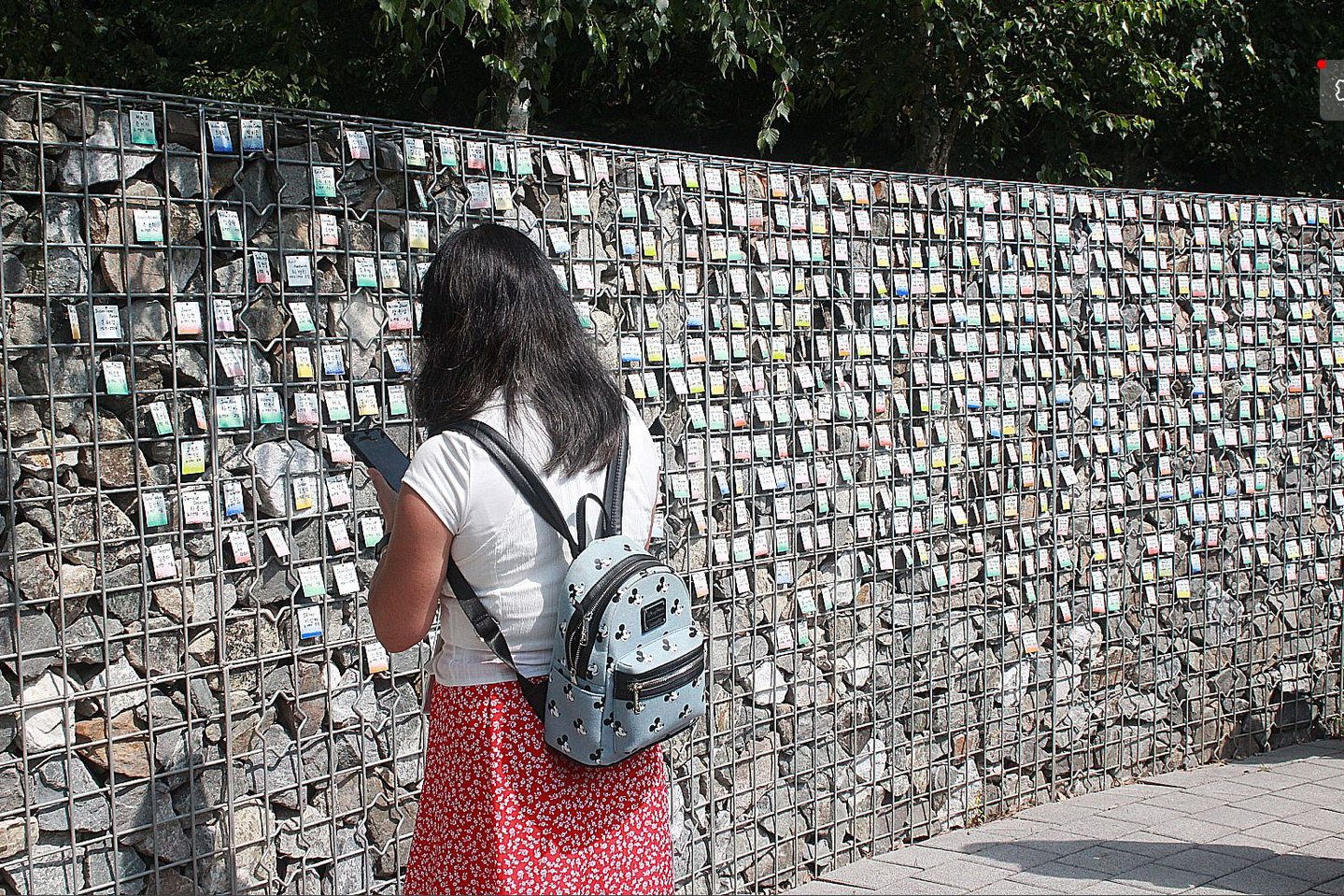 A woman reads nametags of adoptees at a monument in Paju, Gyeonggi, on June 14, 2025. [YONHAP]