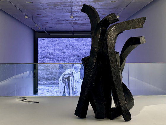 A "Brushstroke" sculpture, front, by the artist Lee Bae and a video clip of him farming at his hometown, Cheongdo, North Gyeongsang, are on display at his solo show "En attendant: Waiting" at Museum SAN in Wonju, Gangwon, on April 6. [LEE JIAN]