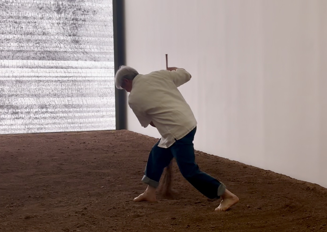 Artist Lee Bae performs his signature brushstrokes on the soil taken near his studio and hometown in Cheongdo, North Gyeongsang, at Museum SAN in Wonju, Gangwon, on April 6. [LEE JIAN]