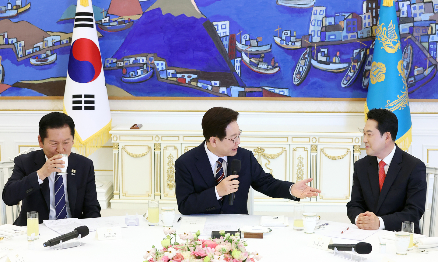 President Lee Jae Myung, center, speaks with main opposition People Power Party chairman Jang Dong-hyeok, right, during a luncheon meeting with the leaders of rival parties to discuss measures to respond to the Middle East crisis at the Blue House in central Seoul on April 7. [JOINT PRESS CORPS]