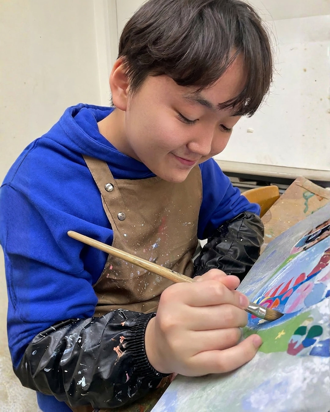 Artist An Dre works on a dinosaur painting in his studio in Ulsan. [AN DRE'S FAMILY]