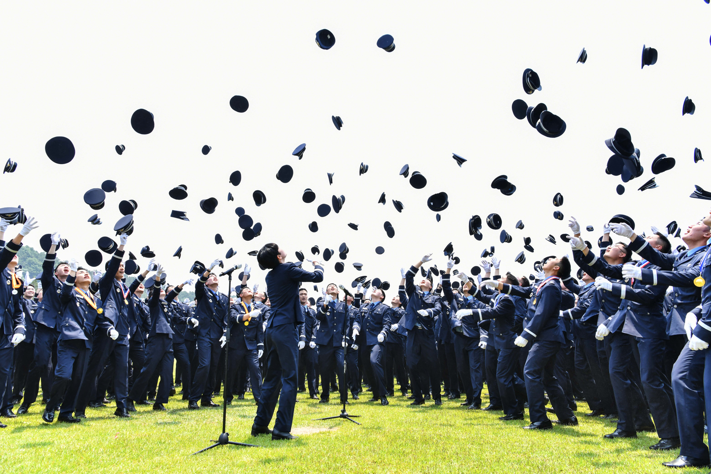 Newly commissioned Air Force officers toss their caps into the air after a commissioning ceremony for the 154th officer candidate class at the parade ground of the Air Force Education and Training Command in Jinju, South Gyeongsang, on May 27, 2025. [YONHAP]