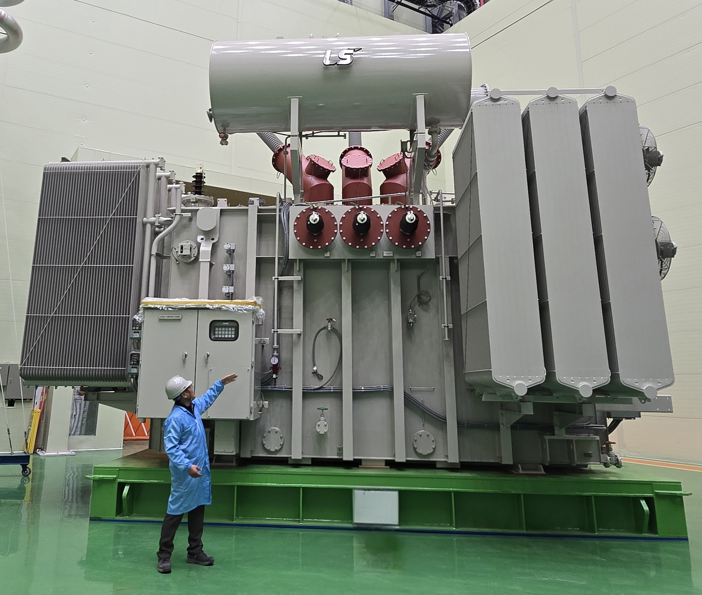 A worker stands in front of an ultra-high-voltage transformer by LS Power Solution. LS Power Solution signed a $70.26 million ultra-high-voltage transformer supply contract with a U.S. energy infrastructure company on April 6. [LS POWER SOLUTION]