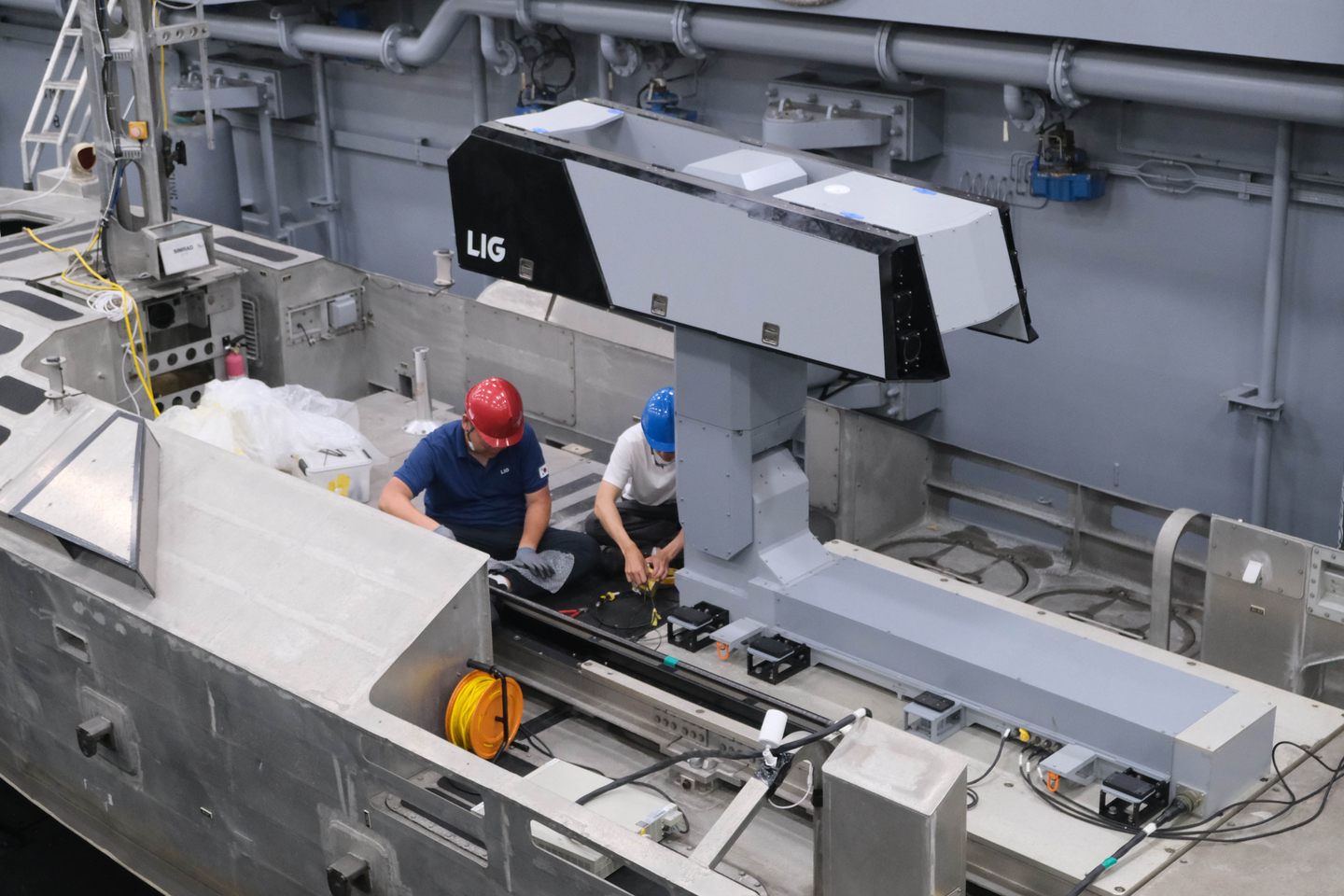 Representatives from LIG D&A inspect a Bigung launcher mounted on an unmanned surface vessel during the Rim of the Pacific Exercise in the United States in July 2024. [LIG D&A]