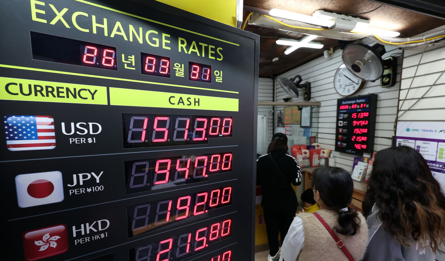 Foreign tourists exchange money at a currency exchange office in Jung District, central Seoul, on March 31. [NEWS1]