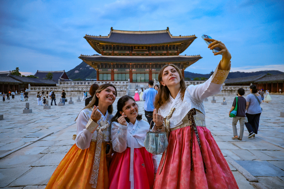 Foreign visitors to Gyeongbok Palace's take selfies in 2025. [NEWS1]