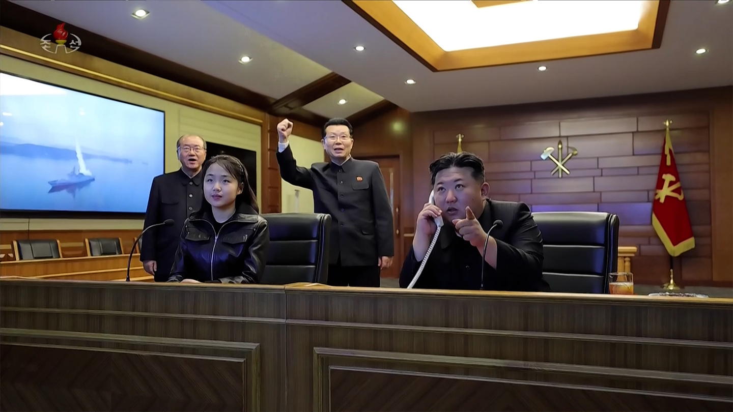 North Korean leader Kim Jong-un, right, and his daughter Kim Ju-ae watch a live feed of a strategic cruise missile test from the destroyer Choe Hyon at an undisclosed location in North Korea on March 10, in a photo carried by Korean Central News Agency the following day. [YONHAP] 