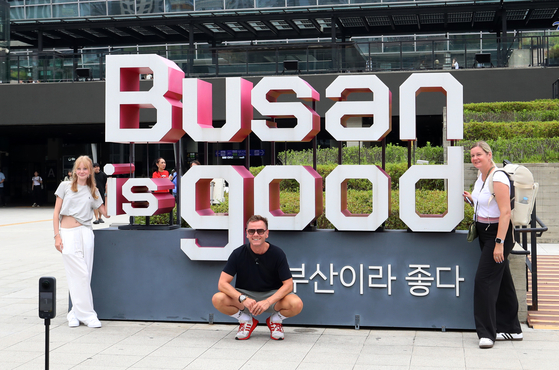 Foreign tourists pose for a photo in front of a "Busan is Good" installation — a slogan for Busan — in July 2025. [NEWS1]