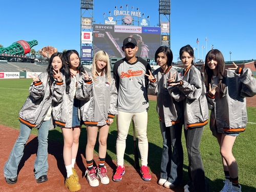 Girl group Nmixx poses for photos with Lee Jung-hoo of the San Francisco Giants, center, before its performance and ceremonial pitch for a MLB game between the Giants and the Philadelphia Phillies at Oracle Park in San Francisco on April 6 in this photo provided by JYP Entertainment. [YONHAP]