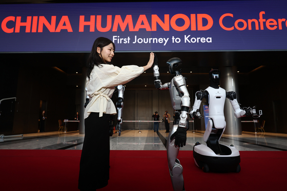 A model interacts with China's Unitree G1 humanoid robot at an expo held at COEX in Seoul on April 4. [YONHAP]