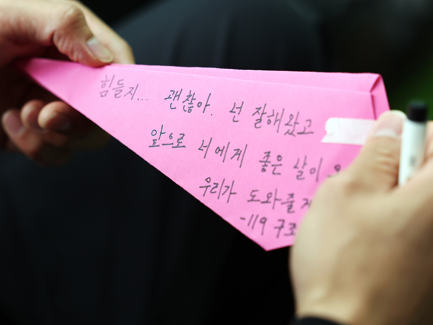A 119 rescue worker writes a message of support on a paper airplane for a social campaign at Yeouido Hangang Park in Seoul on Oct. 15, 2024. [NEWS1]