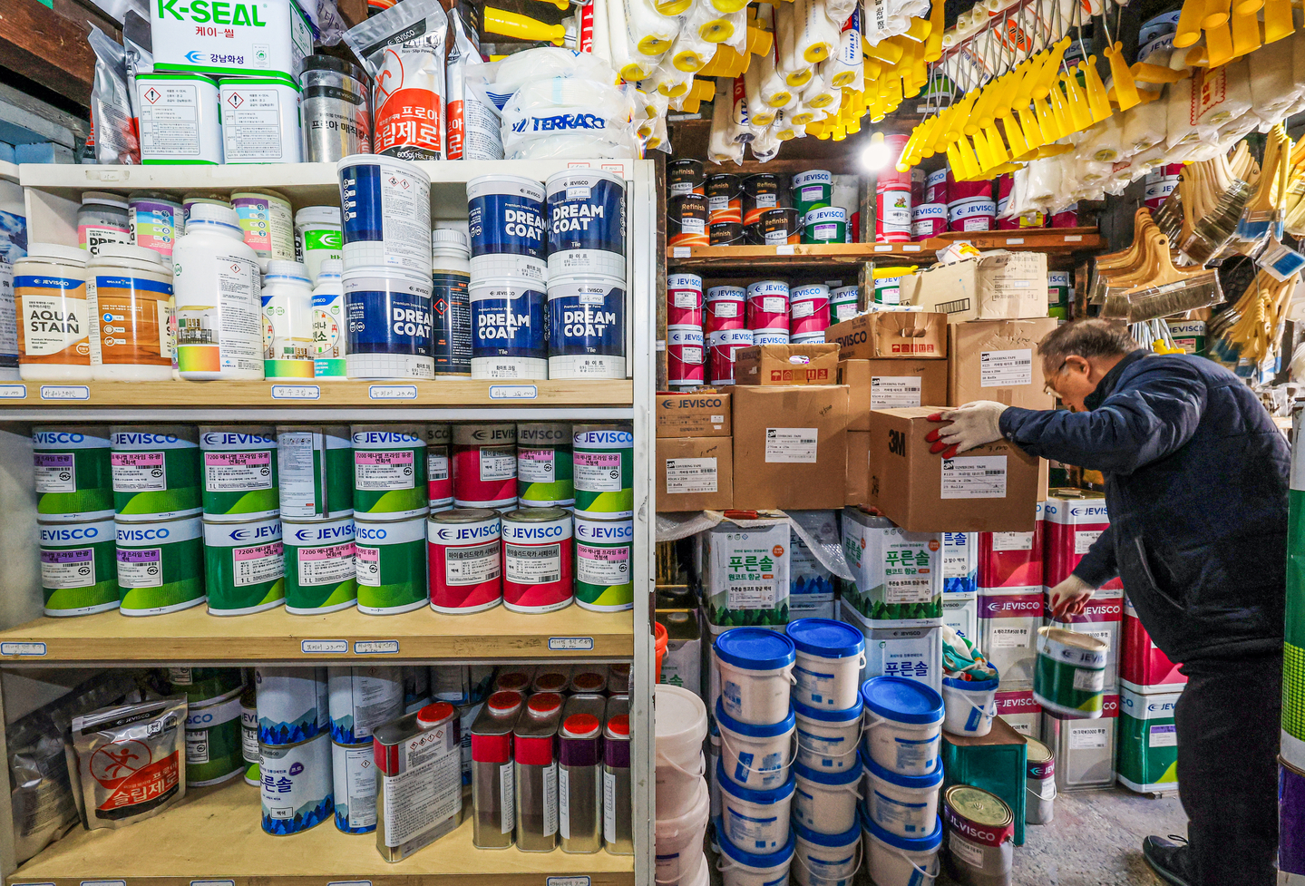 An employee organizes products at a paint retail store in Seoul on March 25. [NEWS1]