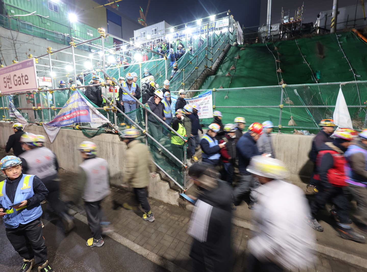 Construction workers leave the Phase 4 site at Samsung Electronics’ Pyeongtaek Campus in Pyeongtaek, Gyeonggi, after finishing their shift around 7 p.m. on Feb. 24. [YONHAP]
