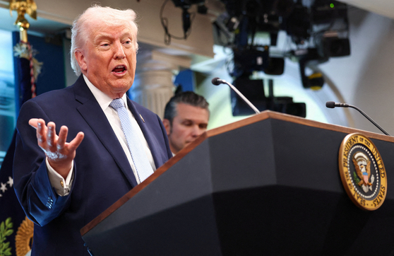 U.S. President Donald Trump, left, flanked by U.S. Secretary of Defense Pete Hegseth, speaks during a press conference in the James S. Brady Press Briefing Room at the White House in Washington on April 6. [REUTERS/YONHAP]