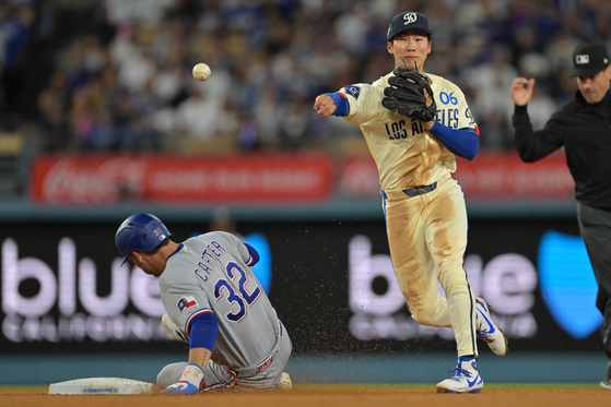 Texas Rangers center fielder Evan Carter, left, is out at second as Los Angeles Dodgers second baseman Kim Hye-seong throws to first for a double play in the fifth inning at Dodger Stadium, Los Angeles. [JAYNE KAMIN-ONCEA-IMAGN IMAGES, REUTERS/YONHAP] 