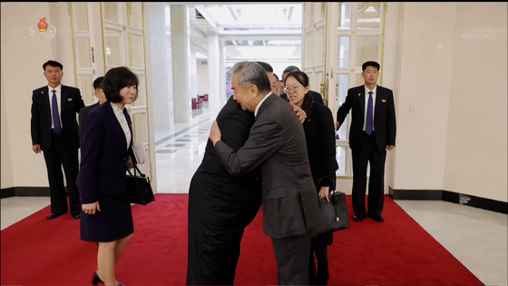 Kim Jong-un, left, bids goodbye to Chinese Foreign Minister Wang Yi during the minister's visit to Pyongyang on April 10, in this screenshot from a video released by the Korean Central Television. [YONHAP] 
