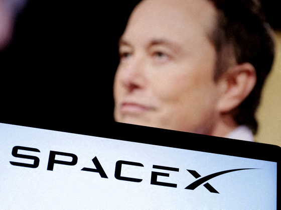 SpaceX's logo and an Elon Musk photo are seen in this illustration created on Dec. 19, 2022. [REUTERS/YONHAP]