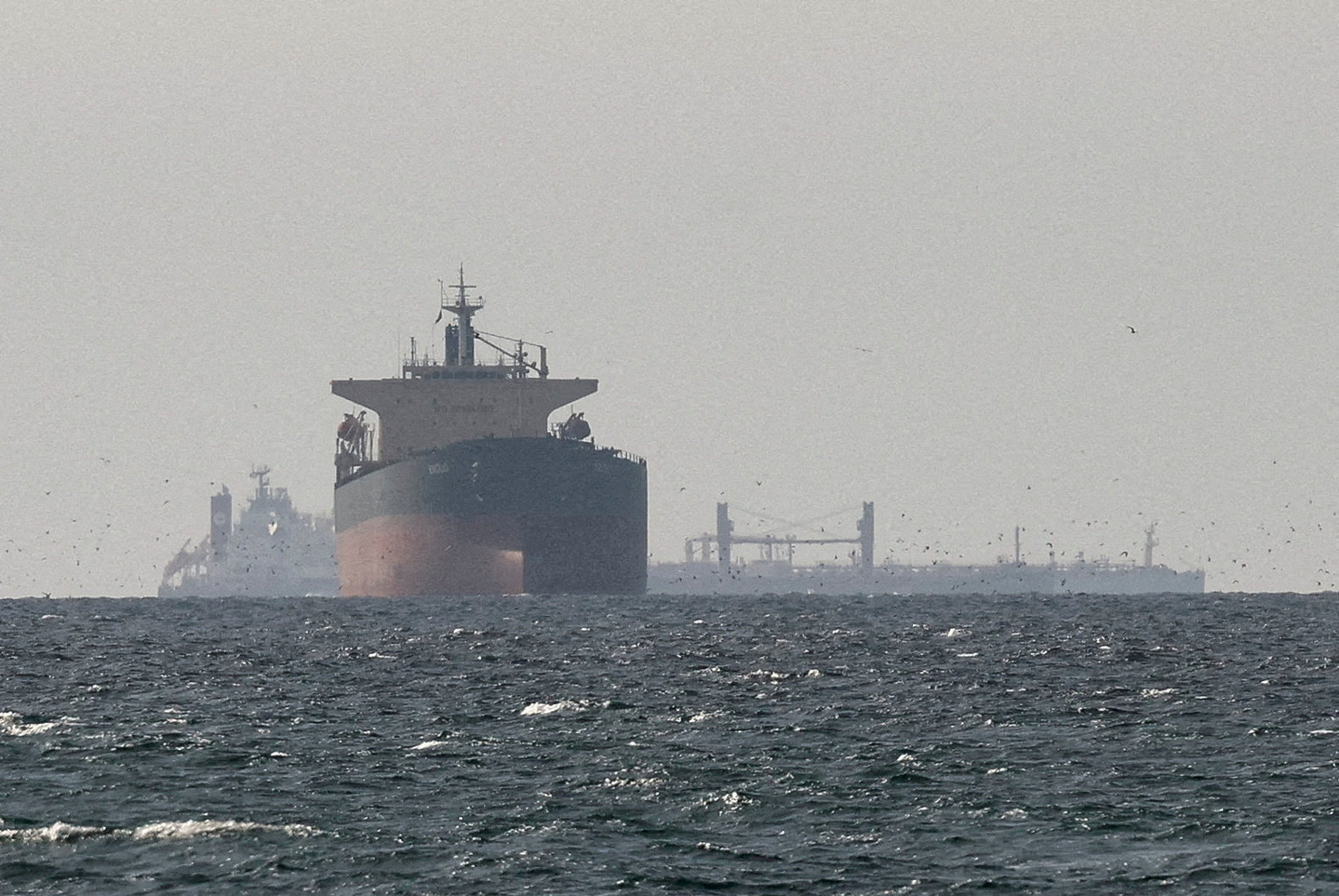 Cargo ships in the Gulf, near the Strait of Hormuz, as seen from northern Ras al-Khaimah, near the border with Oman’s Musandam governance, amid the U.S.-Israeli conflict with Iran, in the United Arab Emirates, March 11. [REUTERS/YONHAP]