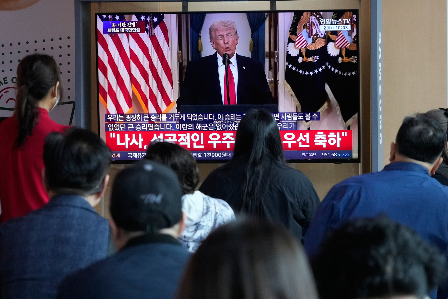 People watch a TV screen showing a live broadcast of U.S. President Donald Trump's speech at the Seoul Railway Station in Seoul on April 2. [AP/YONHAP]