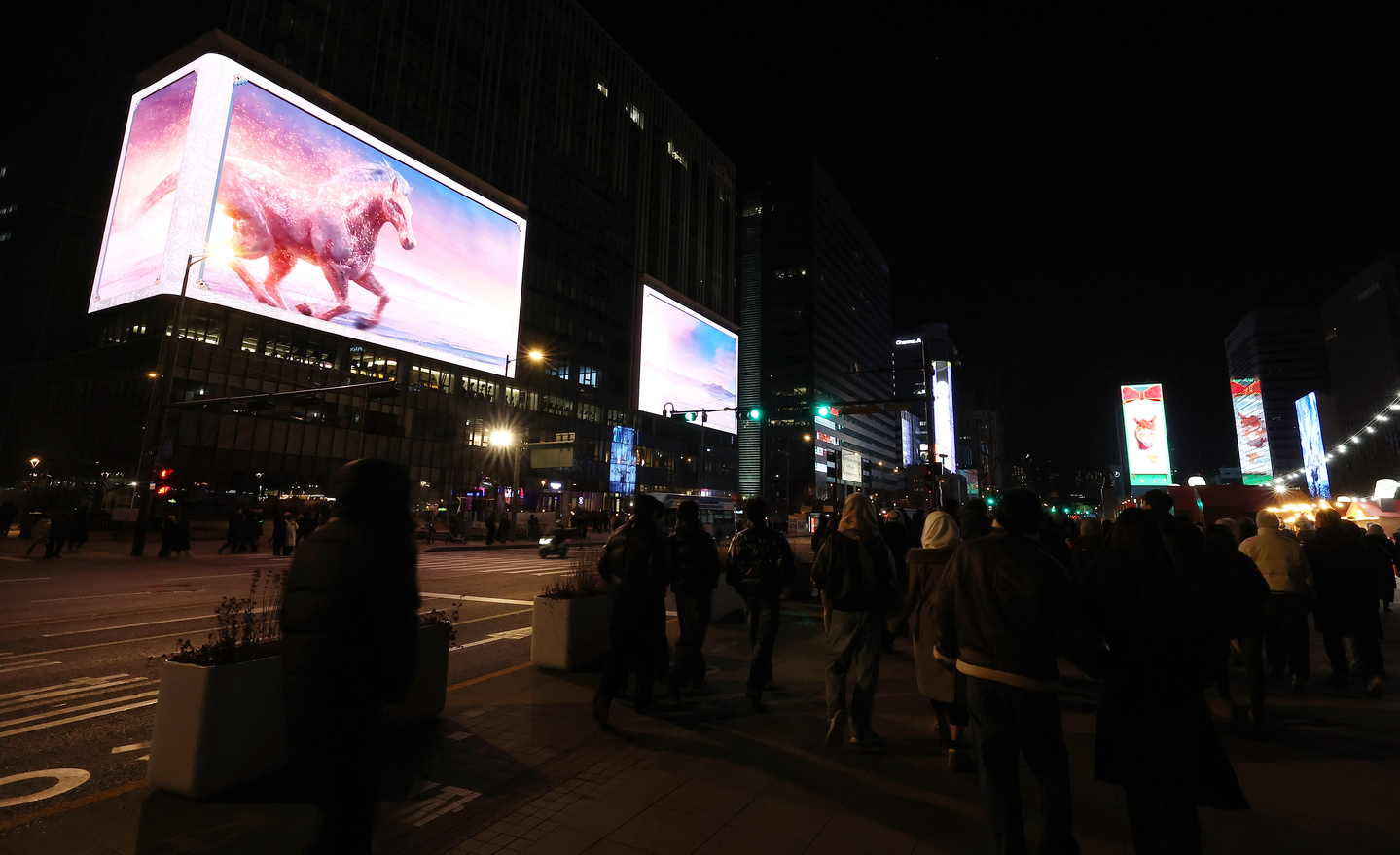 People watch a countdown show on digital displays near Gwanghwamun Square in Jongno District, central Seoul, on Jan. 1. [YONHAP] 