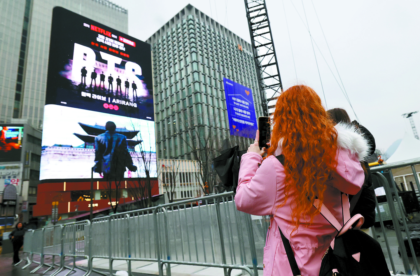 Fans take photos of a digital billboard featuring boy band BTS near Gwanghwamun Square in Jongno District, central Seoul, on March 18. [NEWS1] 