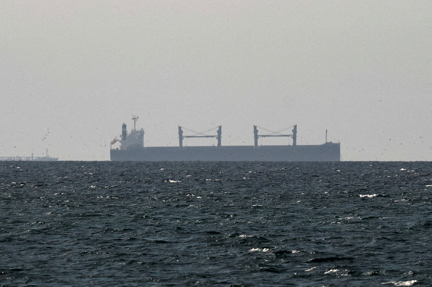 A cargo ship near the Strait of Hormuz as seen from northern Ras al-Khaimah, near the border with Oman’s Musandam governance in the United Arab Emirates on March 11 [REUTERS/YONHAP]