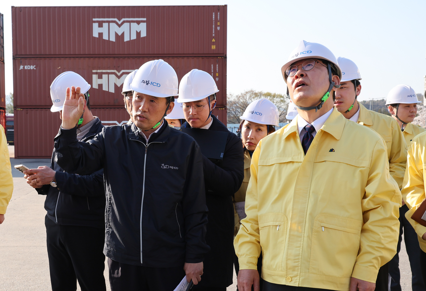 President Lee Jae Myung, right, listens to a site briefing by Jung Gu-yong, CEO of Uiwang Inland Container Depot, during a meeting with the freight transport and logistics industry on measures to cope with high oil prices at the Uiwang ICD in Gyeonggi on April 8. [NEWS1]
