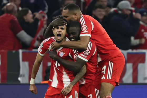 Luis Diaz of Bayern Munich, left, celebrates with his teammates Dayot Upamecano, center, and Jonathan Tah after scoring the 3-3 goal during the UEFA Champions League quarterfinals second-leg match against Real Madrid in Munich on April 15 [EPA/YONHAP]
