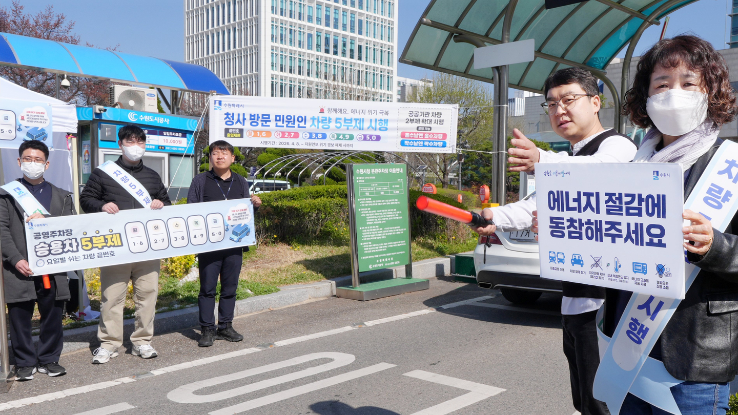 Public officials in Suwon, Gyeonggi, promote the odd-even vehicle restriction system for public institutions and the five-day rotation system for public parking lots at the entrance of the city hall on April 8. [SUWON SPECIAL CITY]