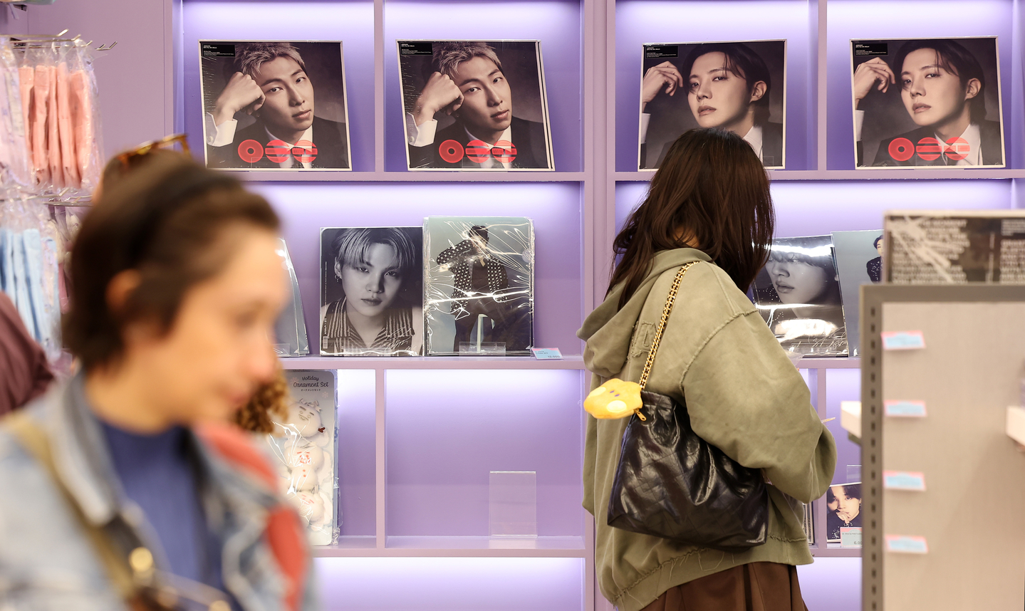 Visitors walk by BTS merch at a store in Jung District, central Seoul, on April 13. [NEWS1]