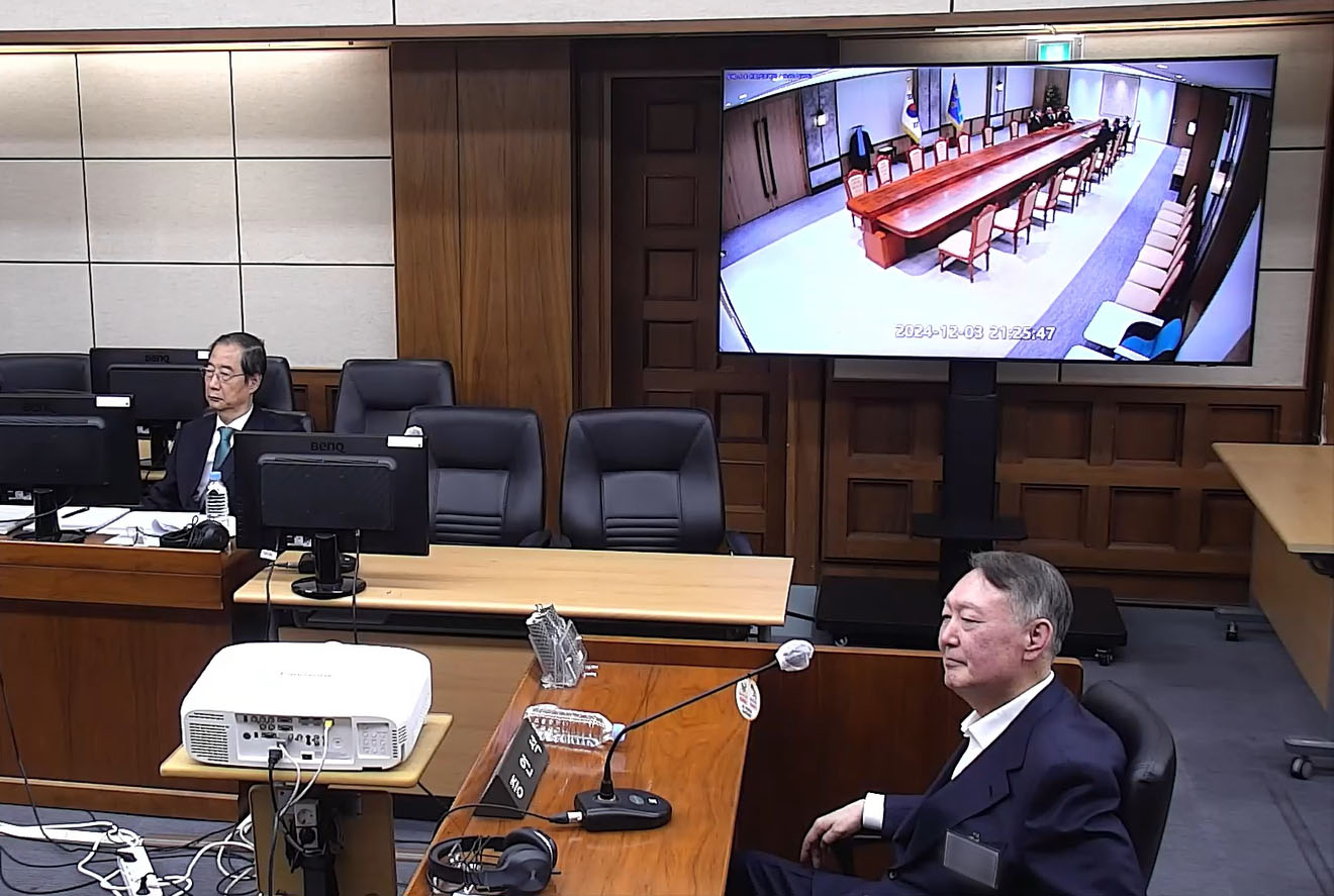 Former President Yoon Suk Yeol, right, attends the insurrection trial of former Prime Minister Han Duck-soo, left, at the Seoul Central District Court in the capital on Nov. 19, 2025, in this file photo provided by the court. [YONHAP] 
