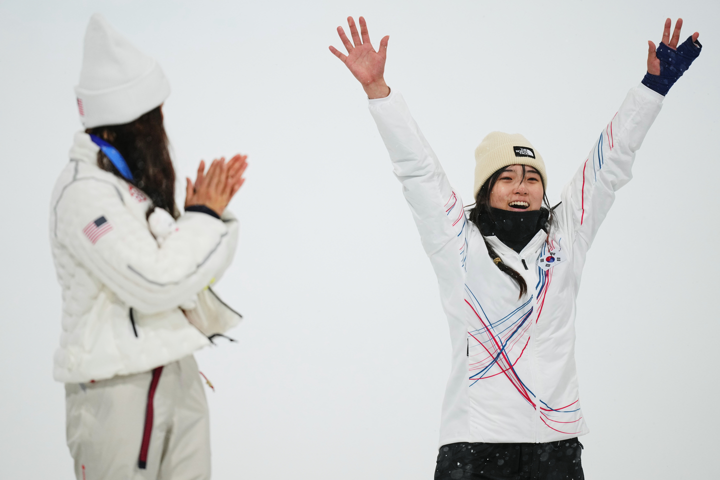 American silver medalist Chloe Kim, left, claps as Korean gold medalist Choi Ga-on celebrates winning the women's snowboarding halfpipe finals at the 2026 Milan-Cortina Winter Olympics, in Livigno, Italy, on Feb. 12. [AP/YONHAP]