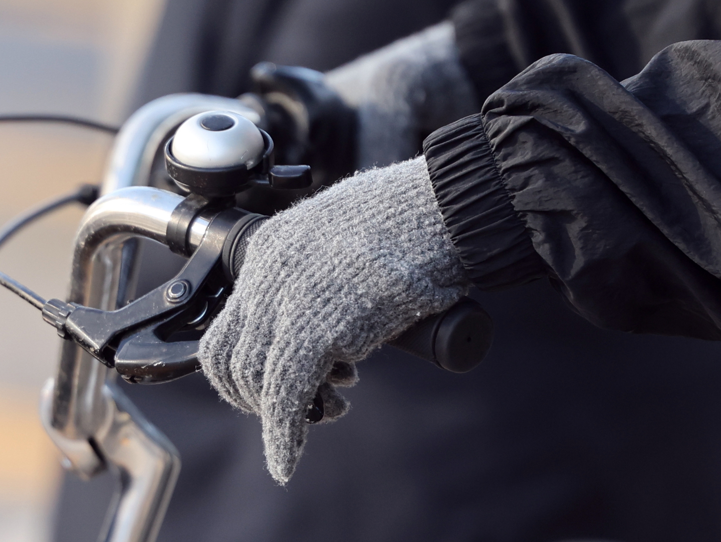 A commuter wearing gloves rides a bicycle at Gwanghwamun in central Seoul on April 7. [NEWS1]
