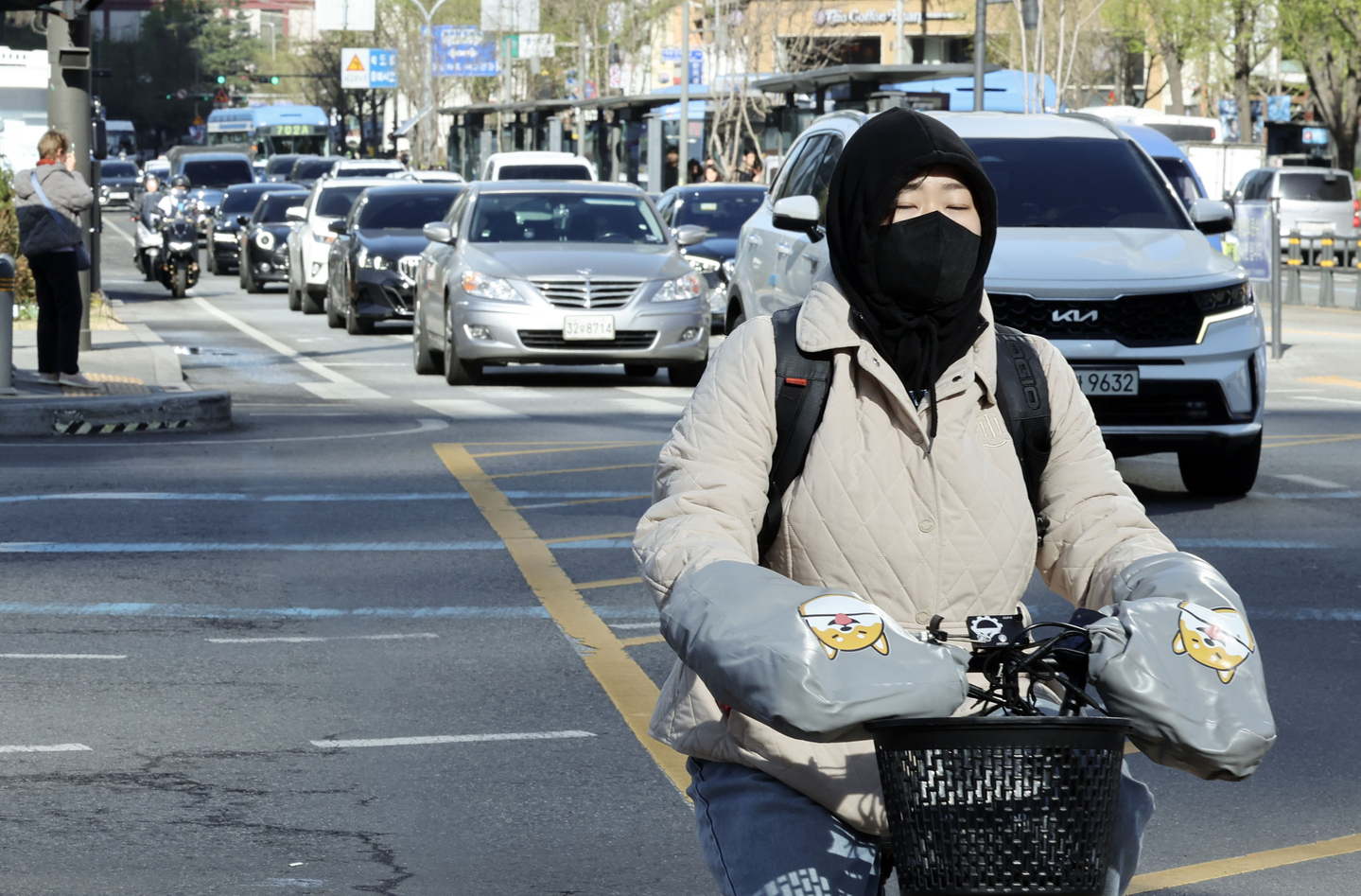 A person dressed in thick clothing rides a bike in central Seoul on April 7. [KIM SEONG-RYONG]