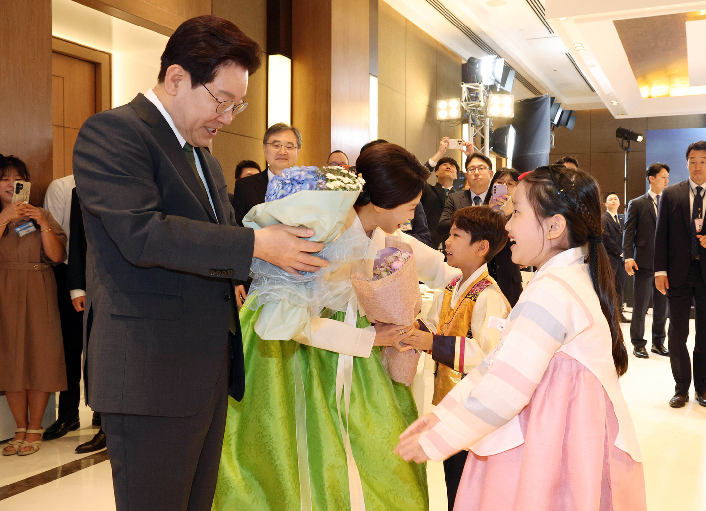 President Lee Jae Myung, left, and first lady Kim Hea Kyung receive flowers from children ahead of a dinner with the Korean diaspora in India at a hotel in New Delhi on April 19 as they begin their three-day state visit to India. [JOINT PRESS CORPS]