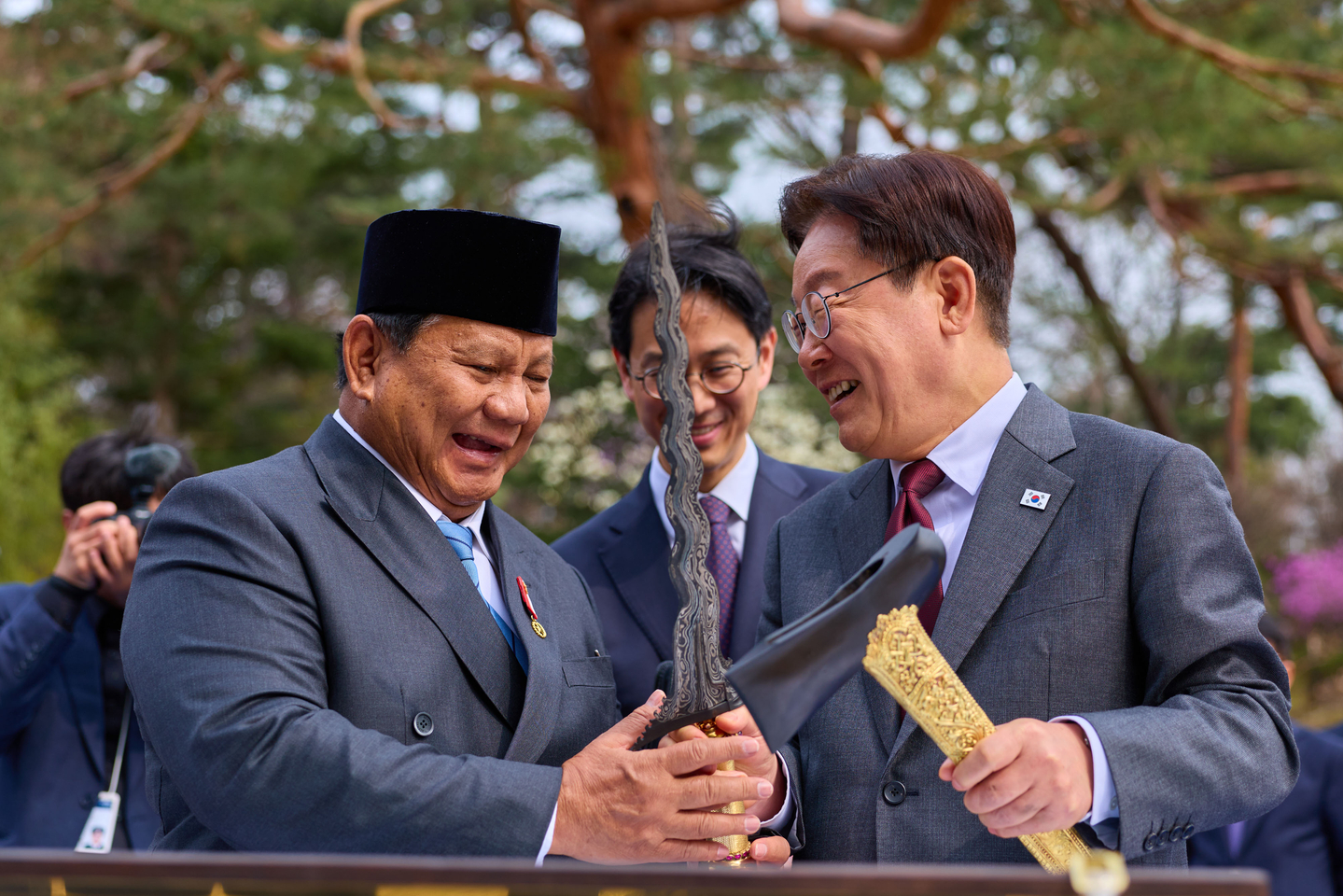 President Lee Jae Myung, right, and Indonesian President Prabowo Subianto chat as they exchange gifts following their bilateral summit as they stroll along Nokjiwon, a lush garden in the Blue House complex in central Seoul, on April 1. [BLUE HOUSE]