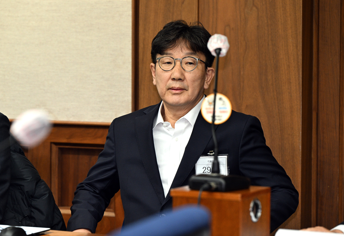 People Power Party Rep. Kweon Seong-dong sits in a courtroom after attending the first hearing in a case over allegations of receiving illegal political funds from the Unification Church at the Seoul Central District Court in southern Seoul on Nov. 3, 2025. [JOINT PRESS CORPS]