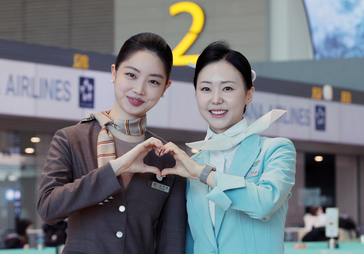 Korean Air and Asiana Airlines cabin crew pose for a photo on Jan. 14 as Asiana began operations at Incheon International Airport Terminal 2. [JOONGANG ILBO]