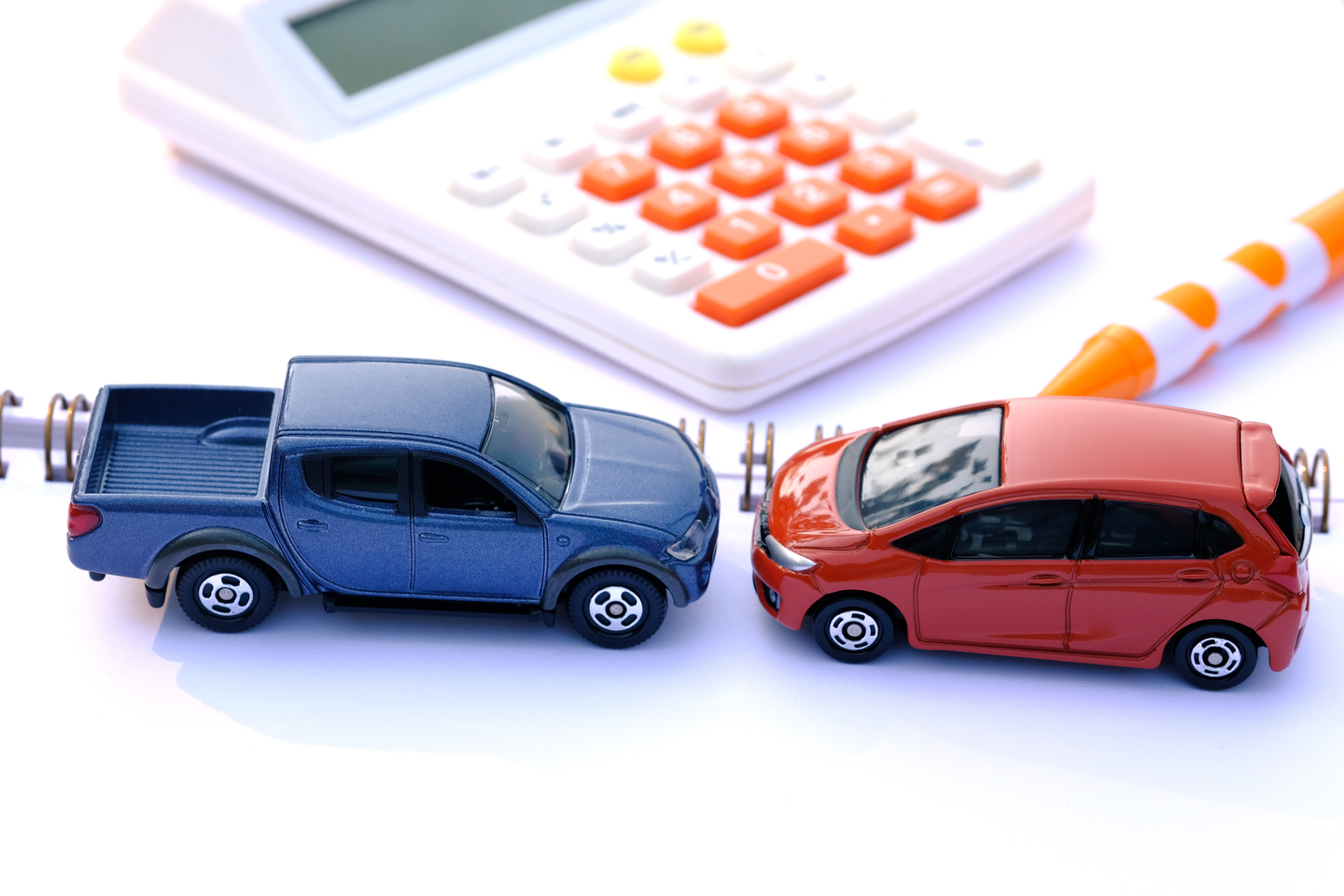 An image of two cars about to collide and a calculator [SHUTTERSTOCK]