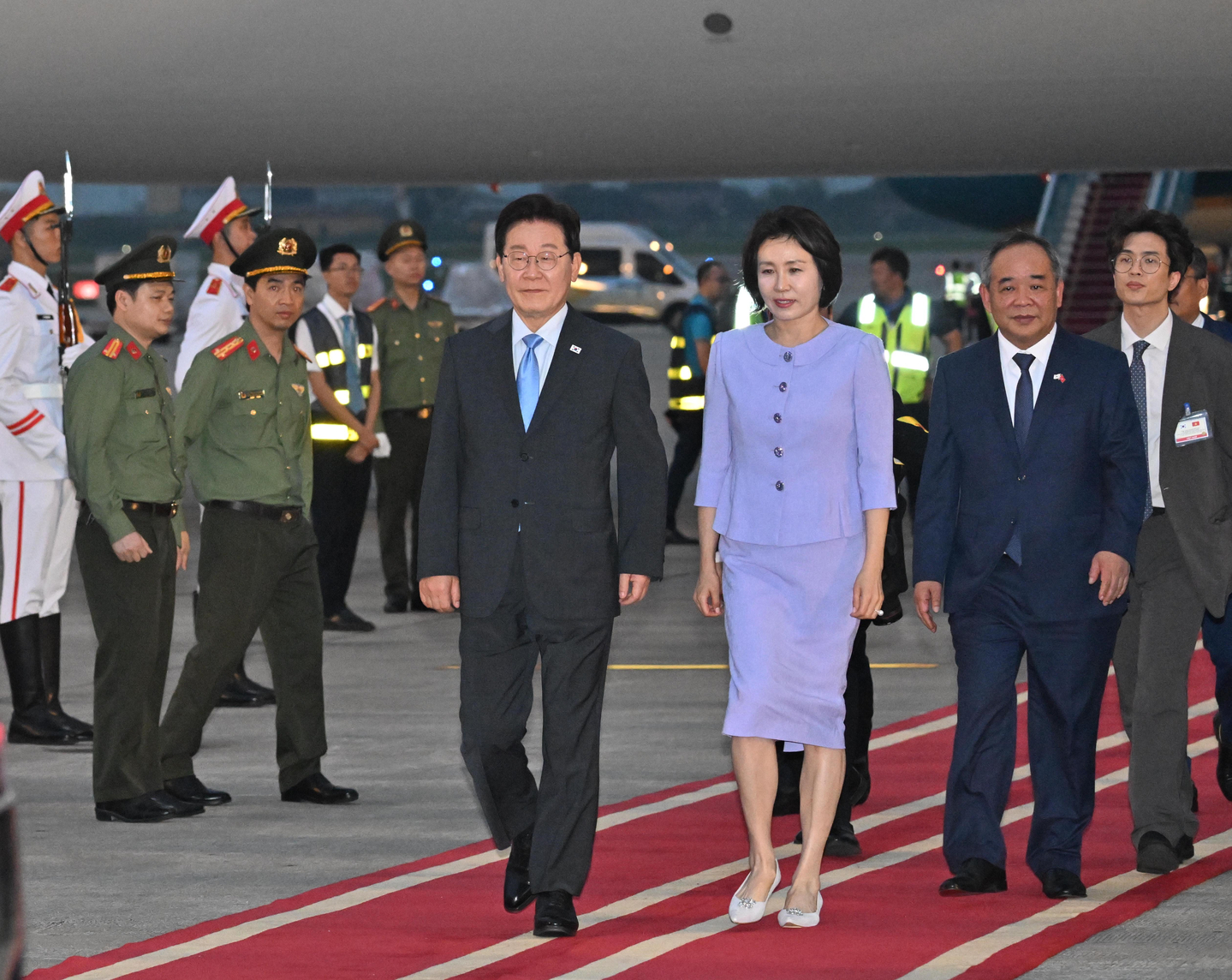 President Lee Jae Myung, front left, and first lady Kim Hea Kyung, front right, arrive at Noi Bai International Airport in Hanoi to begin a three-day state visit to Vietnam on April 21. [JOINT PRESS CORPS] 