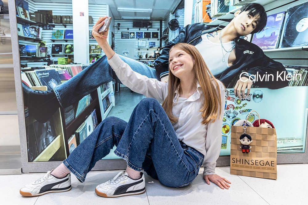 A model takes a selfie with a BTS Jungkook billboard at the Shinsegae Duty Free store in Myeongdong, central Seoul. [SHINSEGAE DUTY FREE]