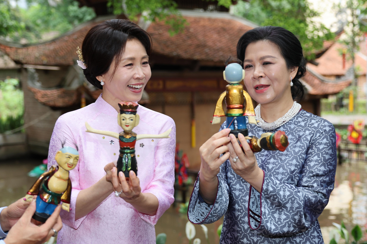 Korean first lady Kim Hea Kyung, left, and Vietnamese first lady Ngo Phuong Ly hold up wood dolls as they visit the Vietnam Museum of Ethnology in Hanoi on April 23. Kim is wearing an ao dai, or a traditional Vietnamese dress, gifted by the Vietnamese first lady. [JOINT PRESS CORPS]