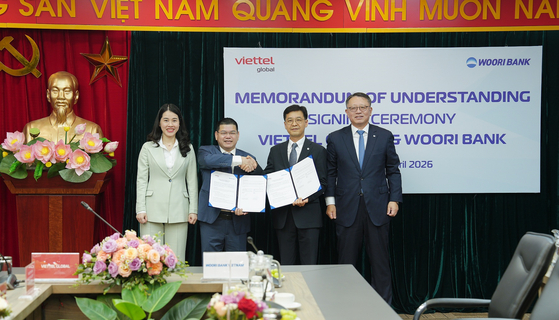 Woori Bank CEO Jung Jin-wan, far right, poses for a photo with Viettel Global General Director Nguyen Thi Hoa, far left, after signing the memorandum of understanding between the two countries at Viettel Global headquarters in Hanoi, Vietnam, on April 22. [WOORI BANK]