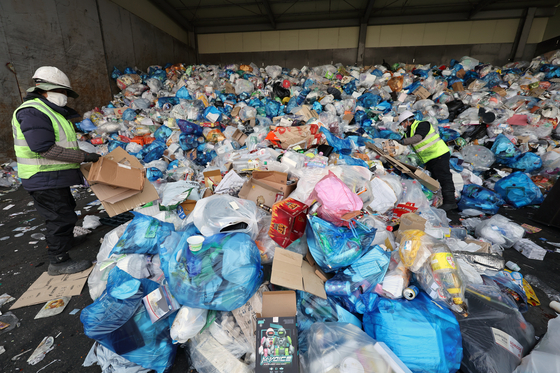 Staffers sort recyclable waste at a recycling sorting facility in Dobong District, western Seoul, on Jan. 26.[NEWS1]