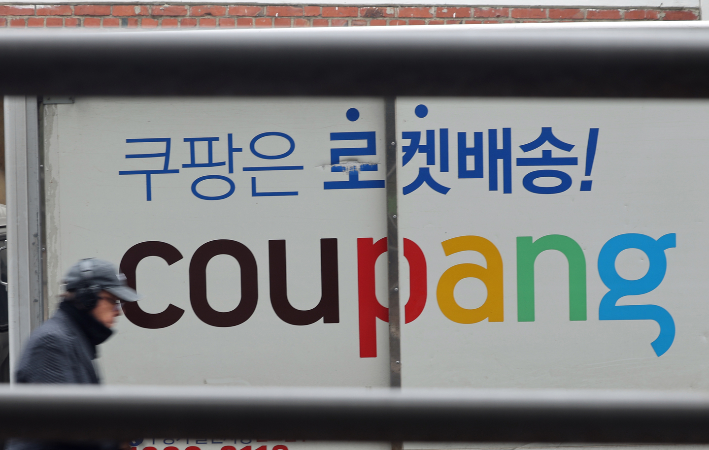 A pedestrian walks by a Coupang logistics center in Seoul on Feb. 10. [NEWS1]