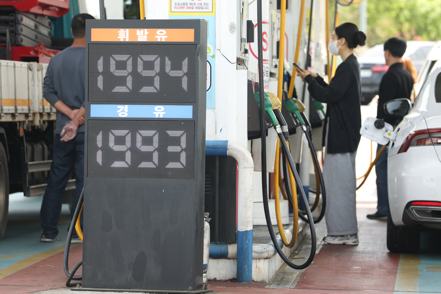 Drivers fuel their cars at a gas station in Seoul on April 23. The price reads as 1,994 won per liter ($5.10 per gallon) for gasoline and 1,993 won per liter for diesel. [YONHAP]
