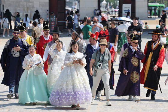 Foreign tourists wearing hanbok, or traditional Korean attire, tour Gyeongbok Palace in downtown Seoul on June 13, 2024. [YONHAP] 