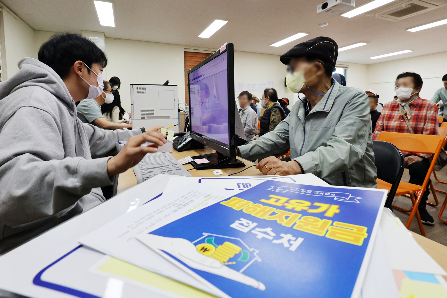 An older adult talks with a civil servant on April 27, as cash assistance for basic livelihood security recipients and other vulnerable groups began rolling out the same day. [YONHAP]